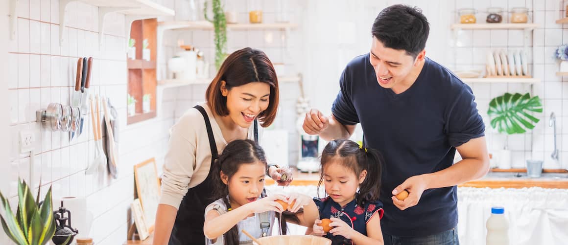 Asian American family cooking in the kitchen together.