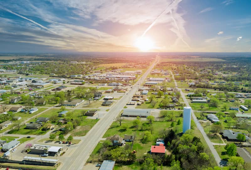 Scenic view of Stroud, OK, with houses, large yards, farmland and long road.