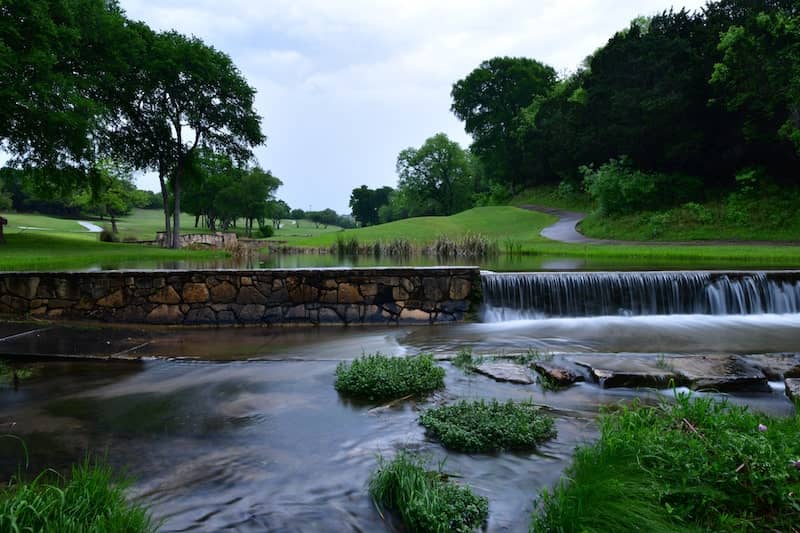 Gold course cart path crossing a small stream late in the evening after a rain shower in Leander TX.