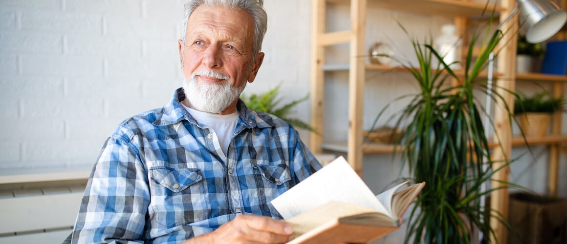 Happy man reading a book at home.