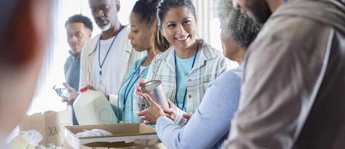 group of people operating a food drive handing food items back and forth