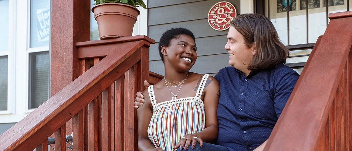 couple sitting on stairs in front of house
