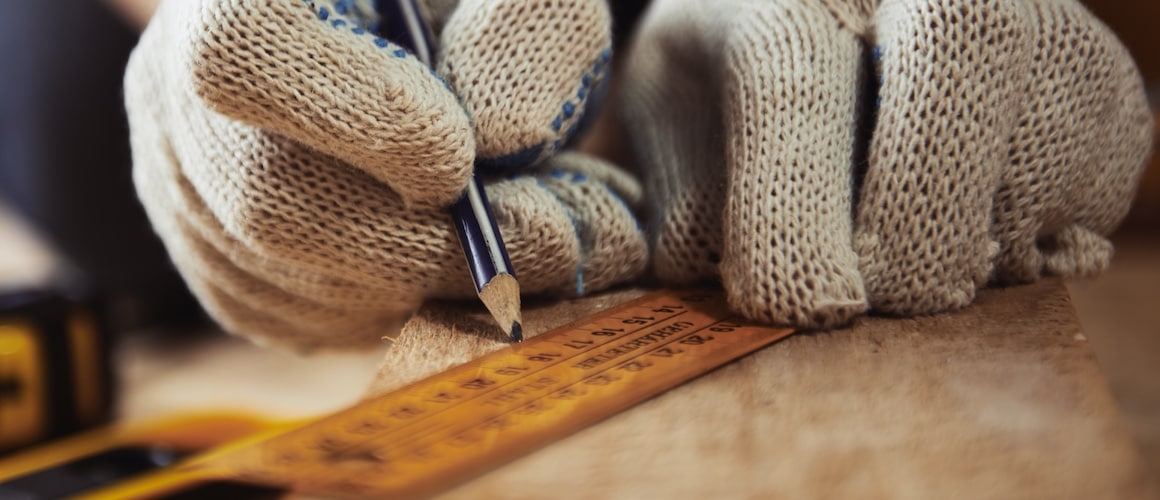 Hands with gloves measuring materials.