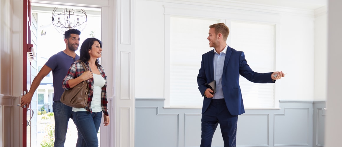 Real estate agent showing couple home.