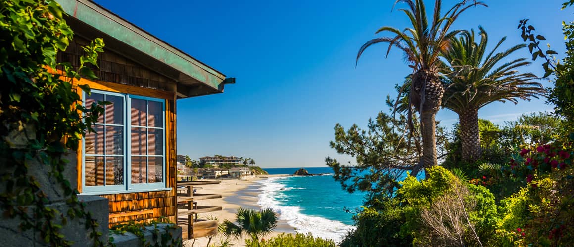 Beachfront home with palm trees and blue water.