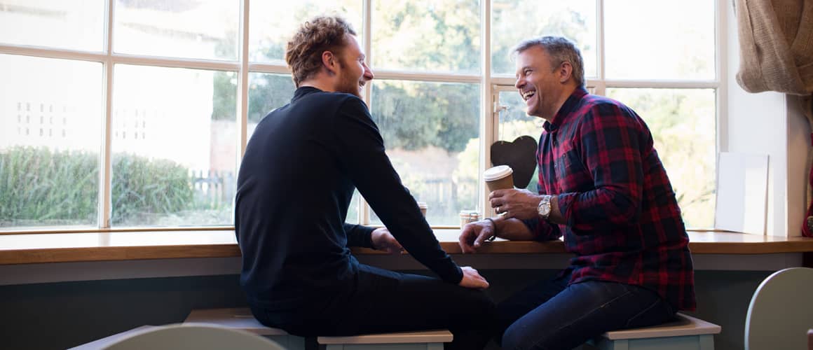 Two men chatting over coffee.