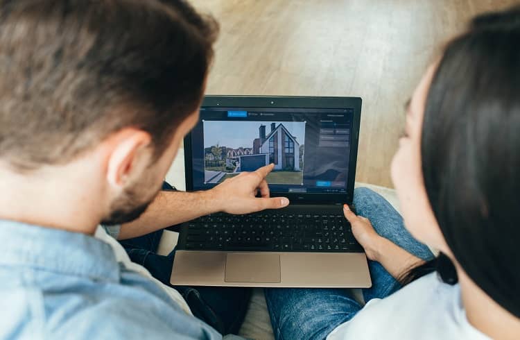 Couple looking on a laptop at a house online