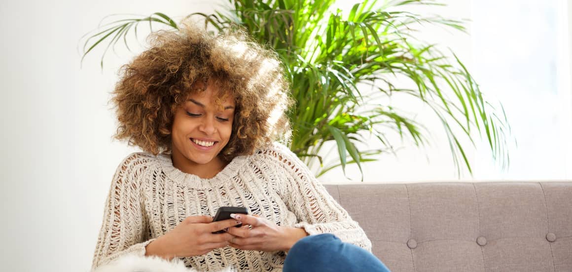 Woman sitting on couch on phone