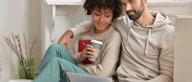 Couple cuddling on the couch while reading