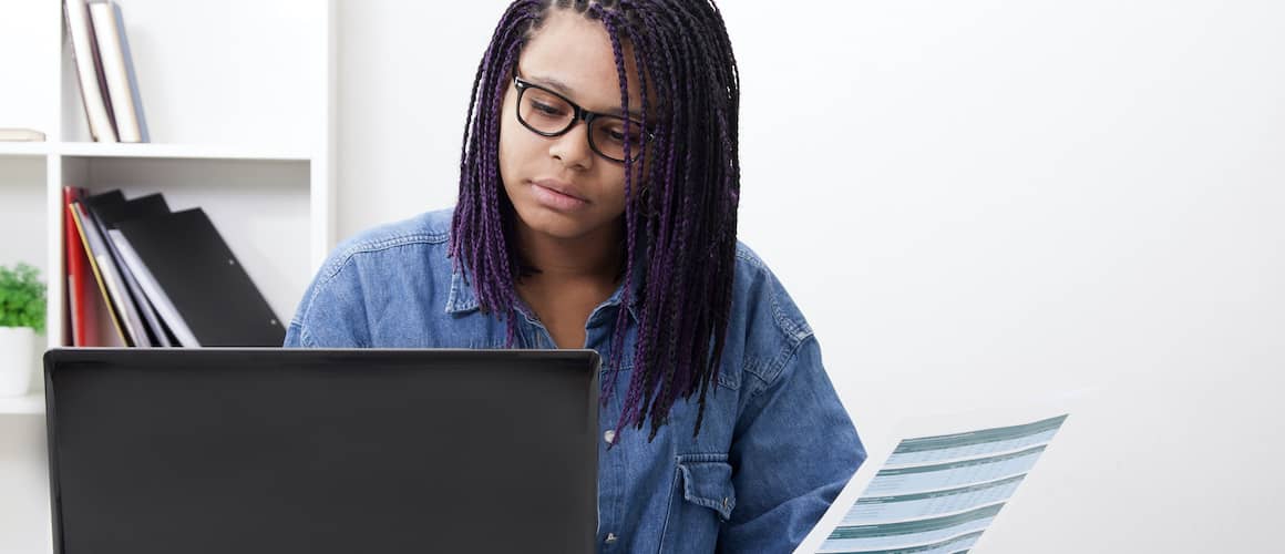 Woman On Computer Holding Paper