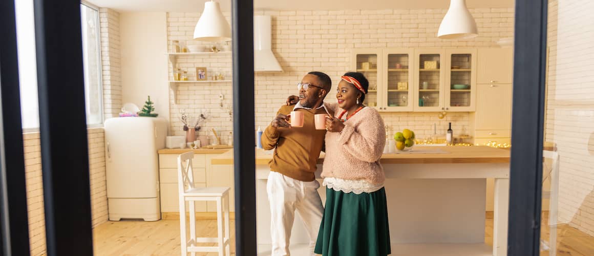 Couple contemplating refinancing to a 15 year mortgage inside their kitchen at home.