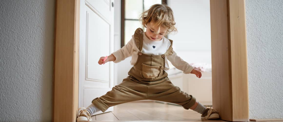 Toddler in doorway of new affordable home.