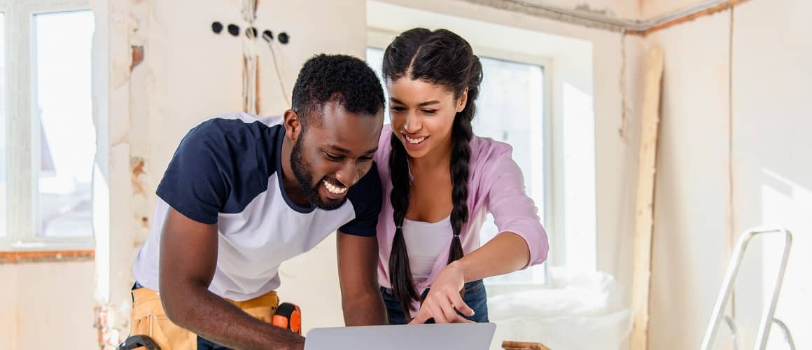 Couple looking over plans together in an in-progress renovated house.