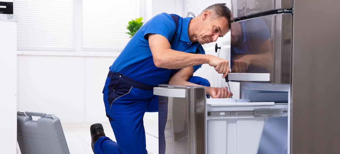 Appliance Repairman working on fridge
