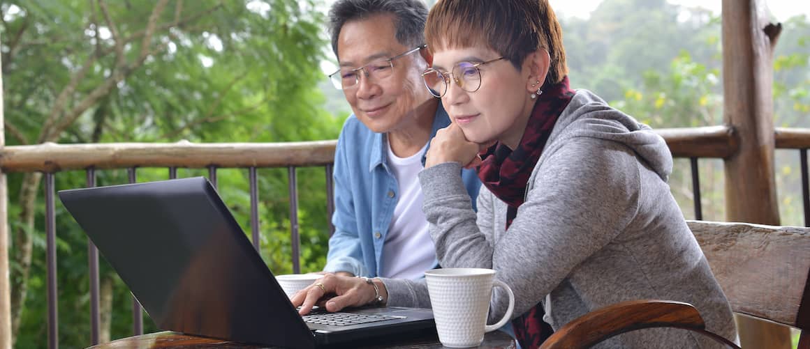 Asian Couple On Back Patio With Laptop