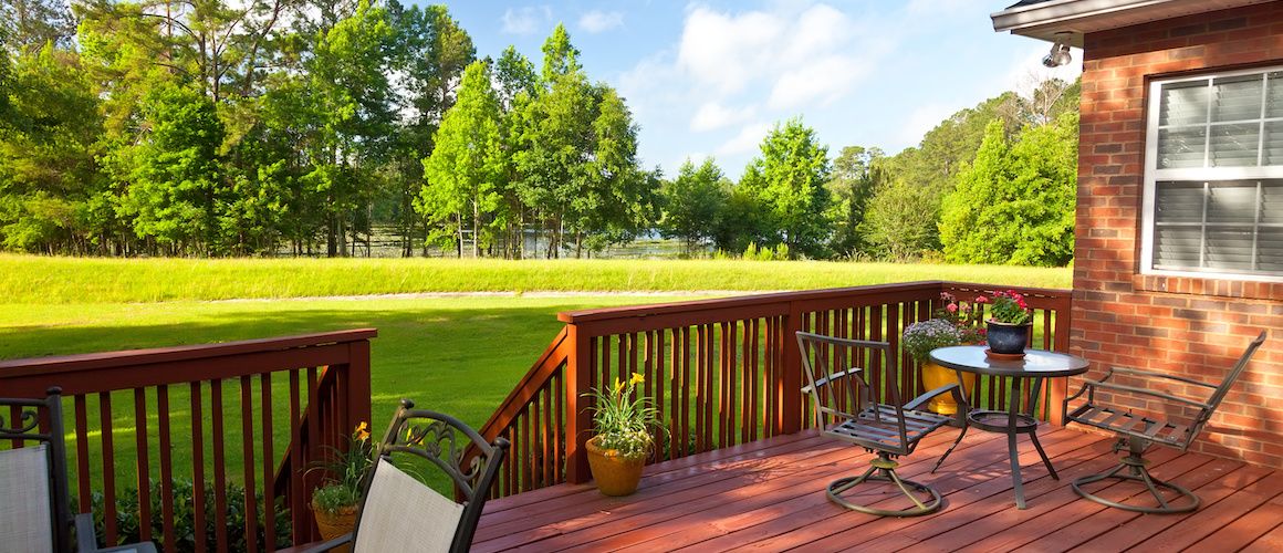 Backyard deck looking out at water and trees.