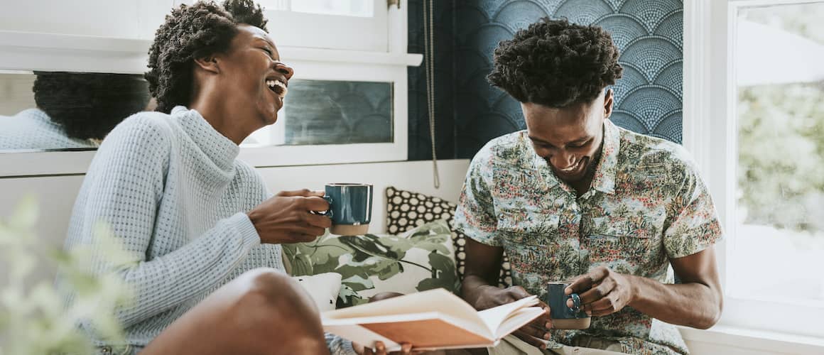 Black Couple In Kitchen Drinking Coffee And Laughing