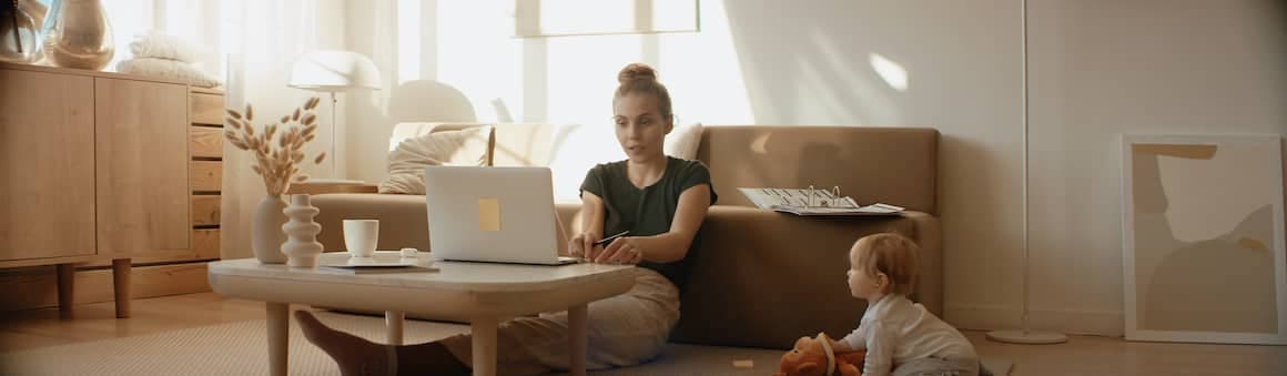 Mother with young child working remotely while determining her refinance break even point