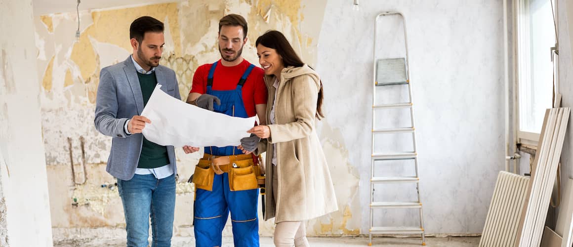 couple meeting with contractor and viewing blueprints