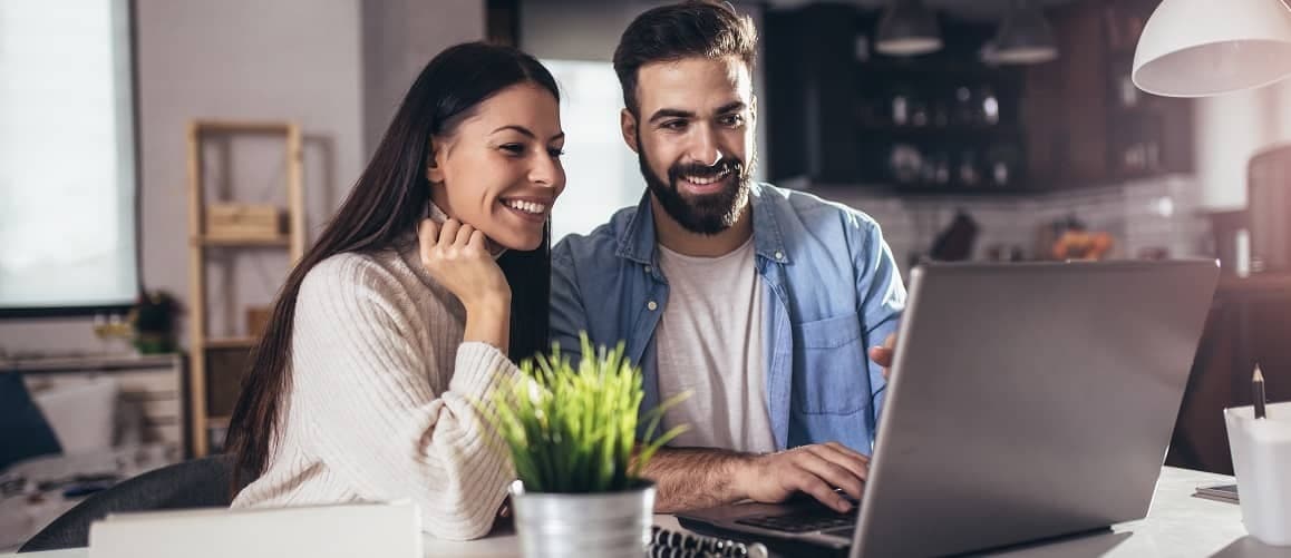 Couple looking at a computer in their house.