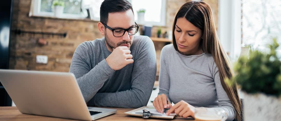 Couple looking at papers in home.