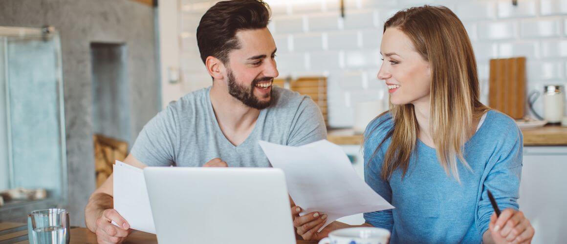Couple in kitchen paying bills.