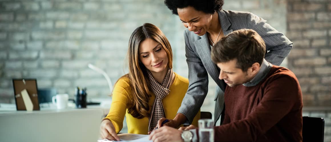 Couple Reviewing Closing Documents With Agent