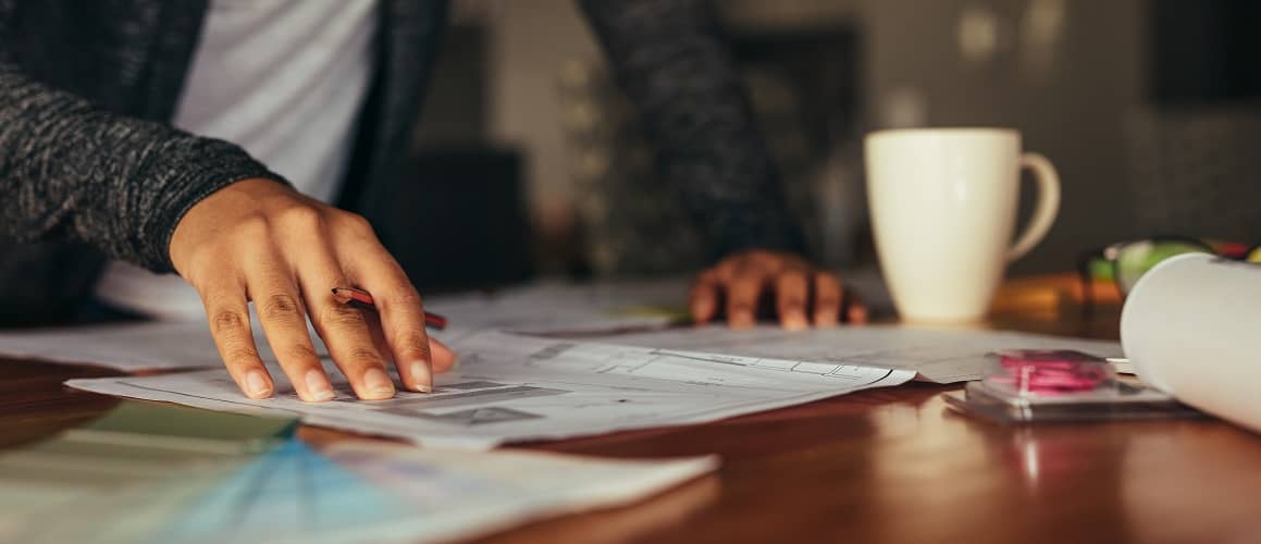 Documents Spread Across Table With Coffee Mug