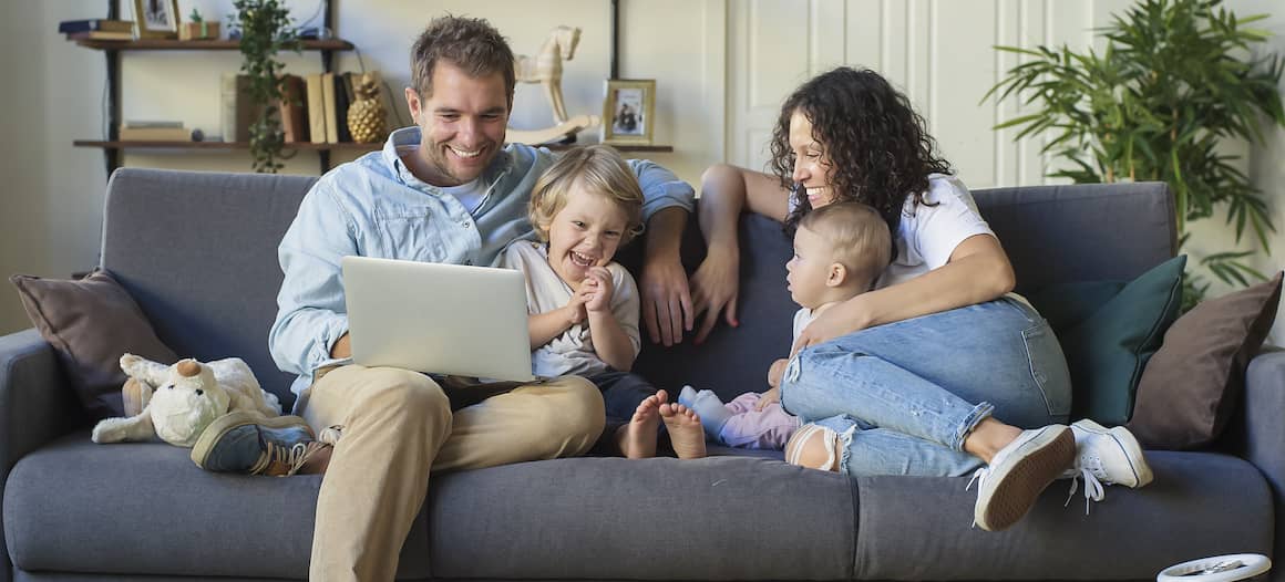 family of 4 sitting together on couch
