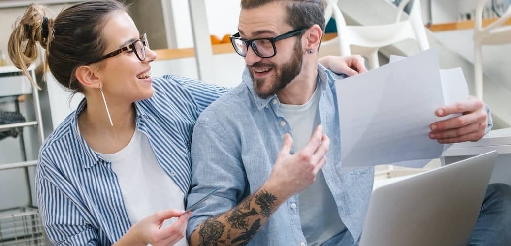 Young Couple Managing Bills On Kitchen Floor