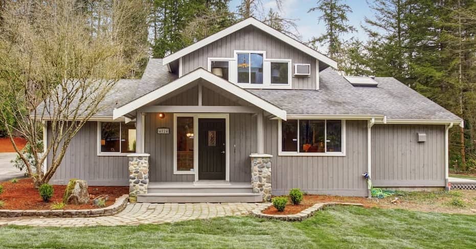 Grey Home With White Framing And Red Mulch