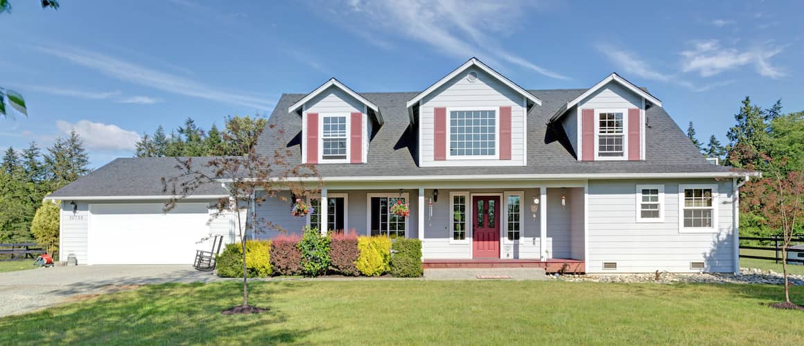 Home exterior with red shutters on a summer day.