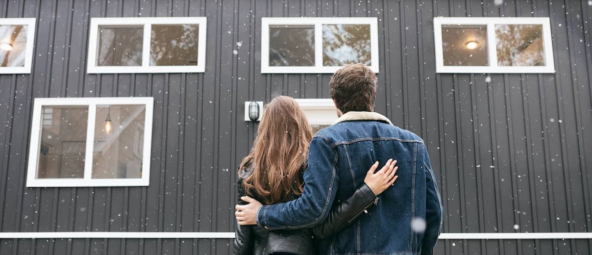 Couple look at kit home while it snows