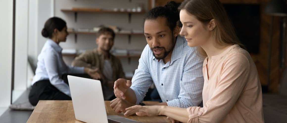 Man describing something on a computer to a woman.