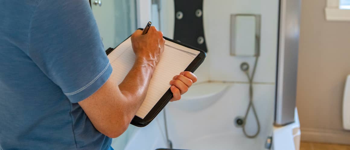 Man Writing Inspection On Bathroom