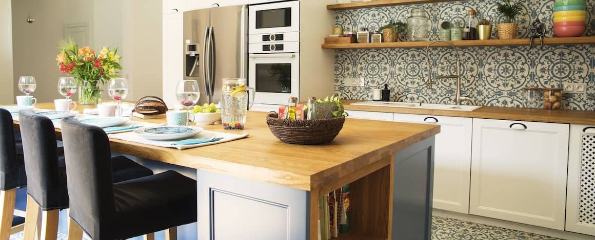 Kitchen with mosaic backsplash and butcher block countertops.