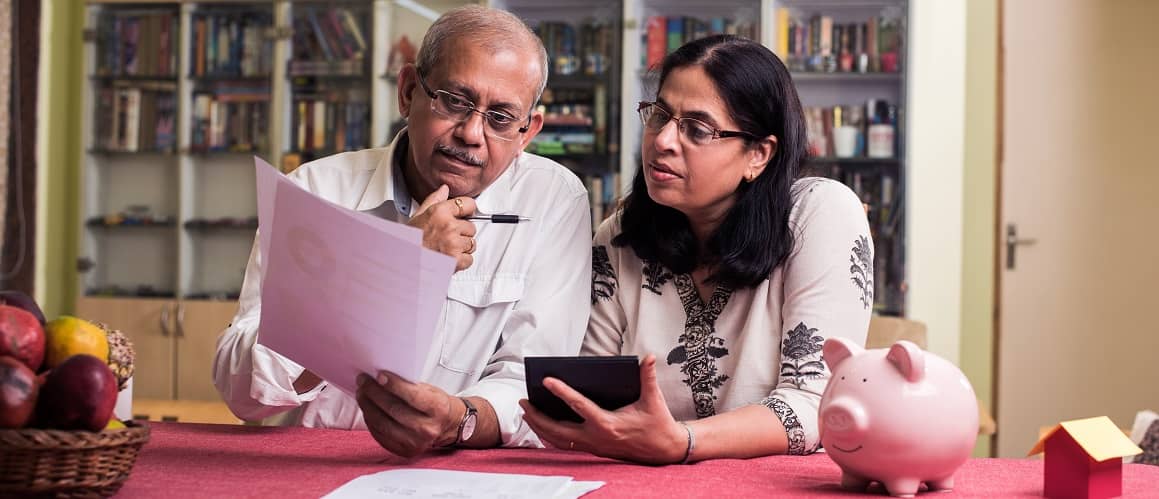 Older couple looking at papers in kitchen