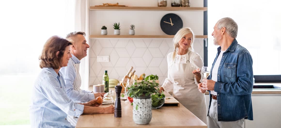 older couple hanging out in kitchen with other older couple