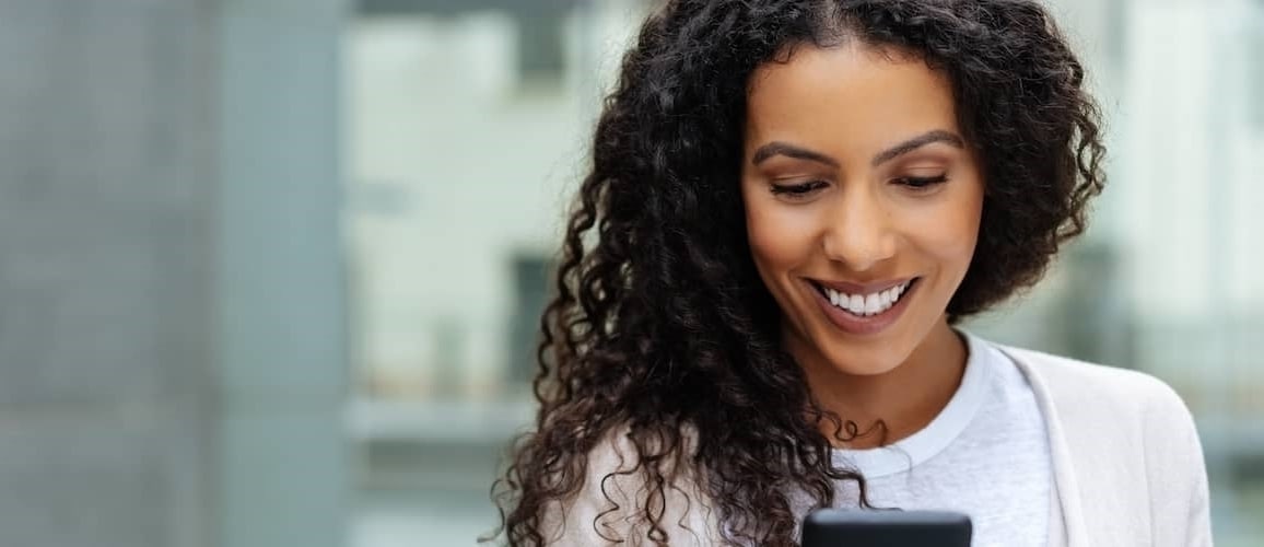 Woman Looking At Smart Phone For Open Houses