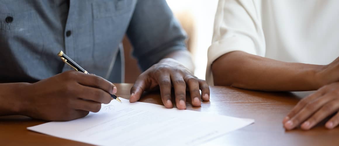 People signing mortgage promissory note.
