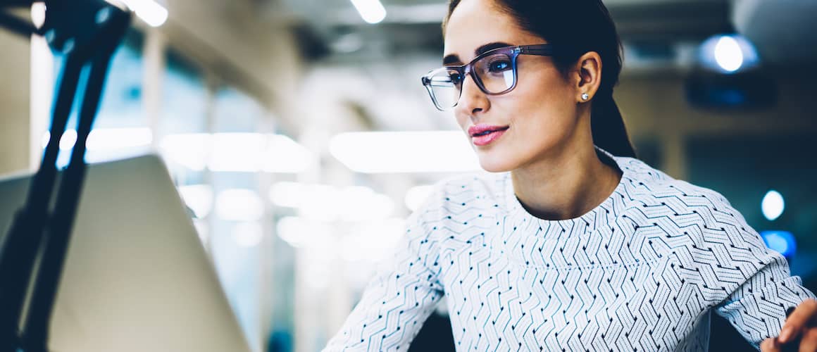 Woman In Glasses Reviewing Mortgage Option Information Online