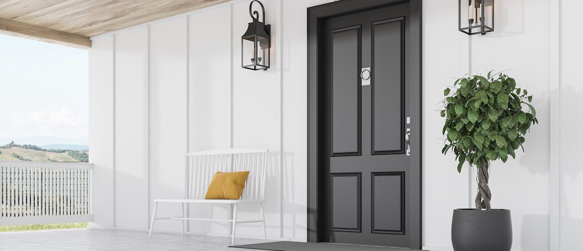 black door on a white house with a bench on the porch.