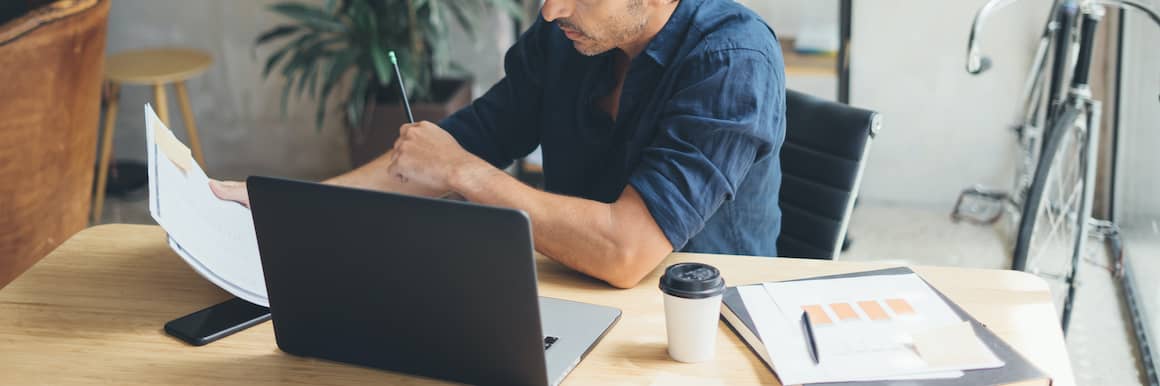 Man working on investments in home office.