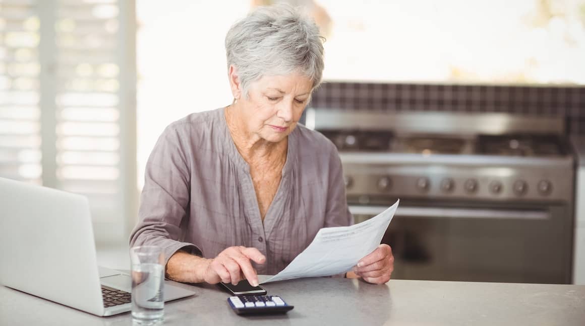senior woman looking at finances and using a calculator