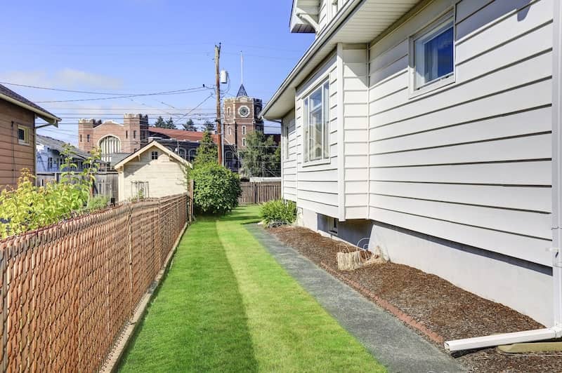 Side of house with small amount of side yard and fence.