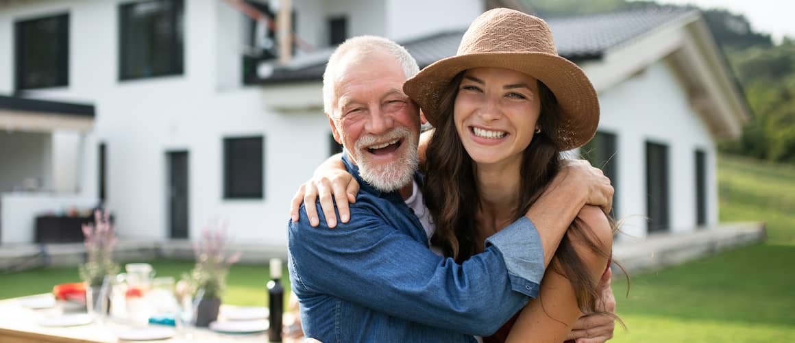 Older Father With Adult Daughter Outside Family Home