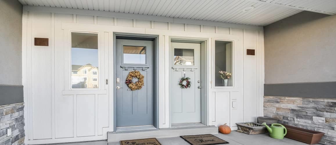 Two doors on the front porch of a duplex.