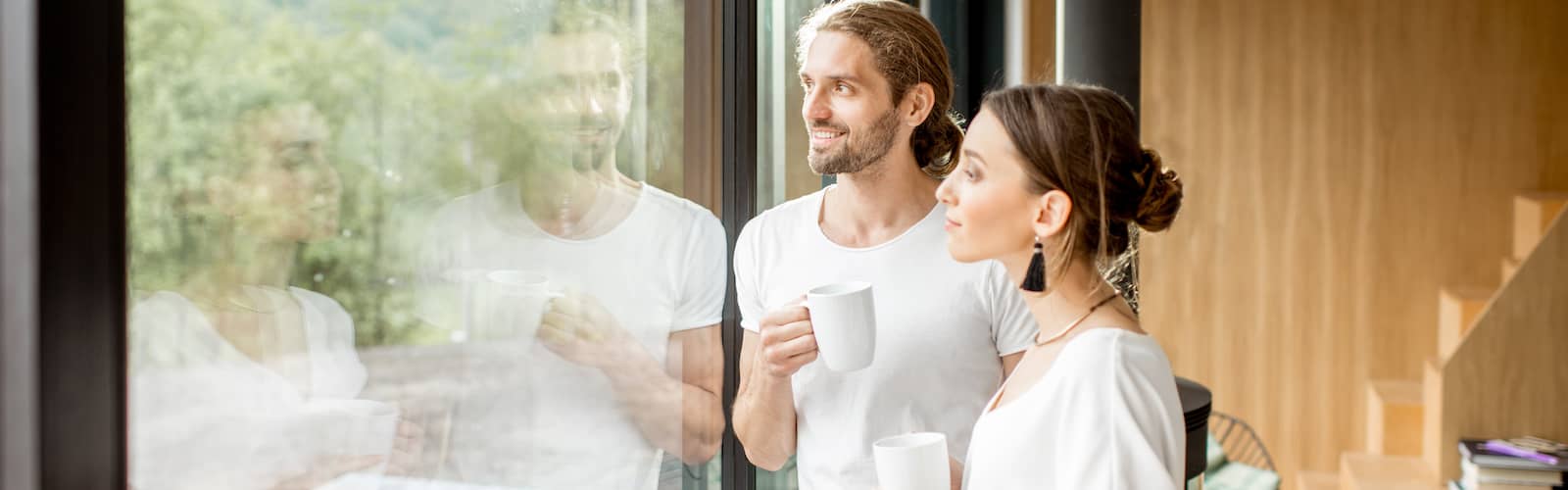 Young couple looking out window of modern home.