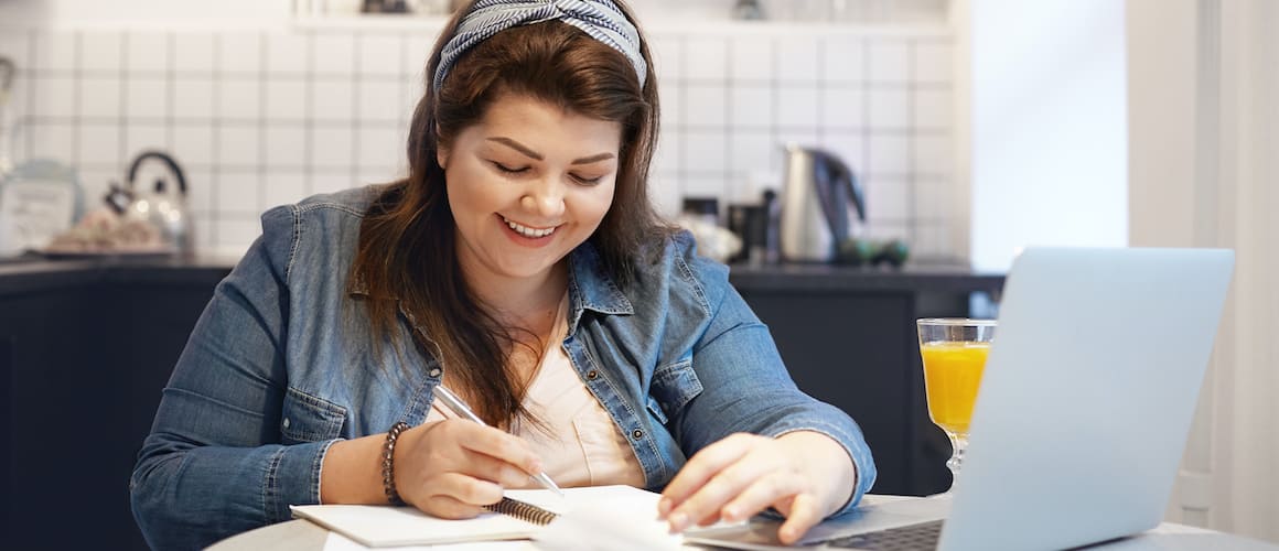 Woman on computer with papers.