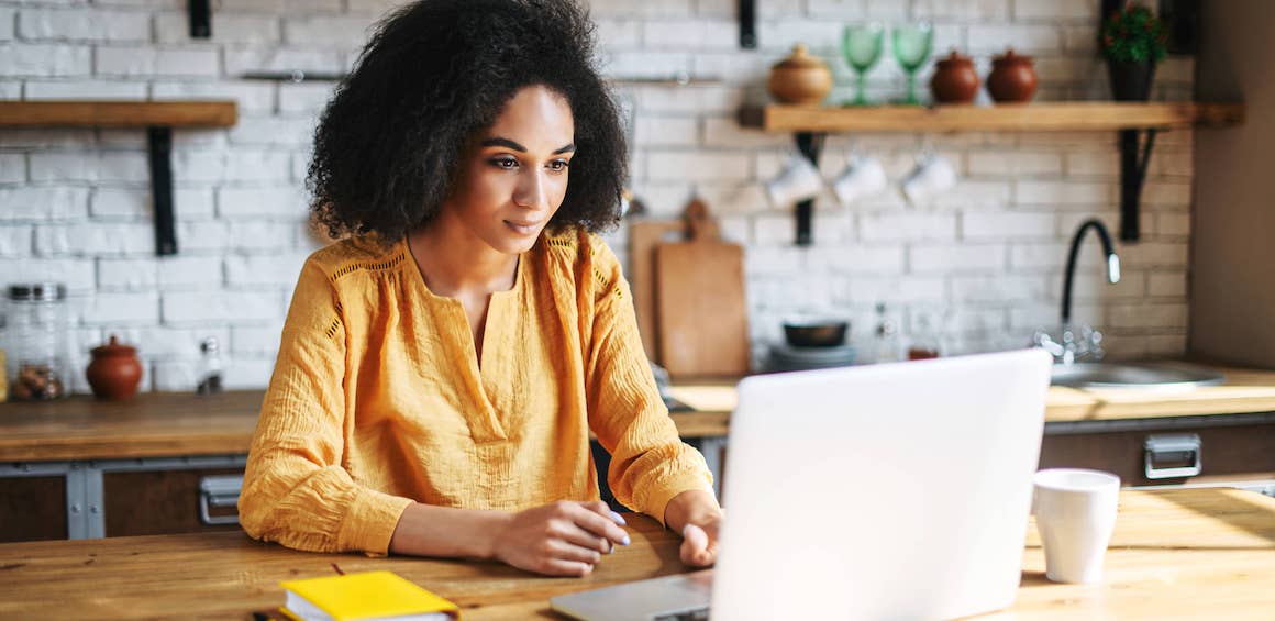 Woman on laptop in kitchen